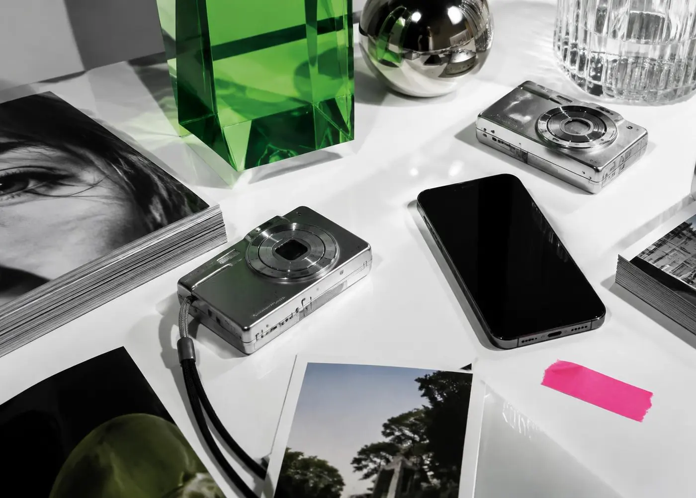 Cameras, prints, and a phone arranged as a social media still life